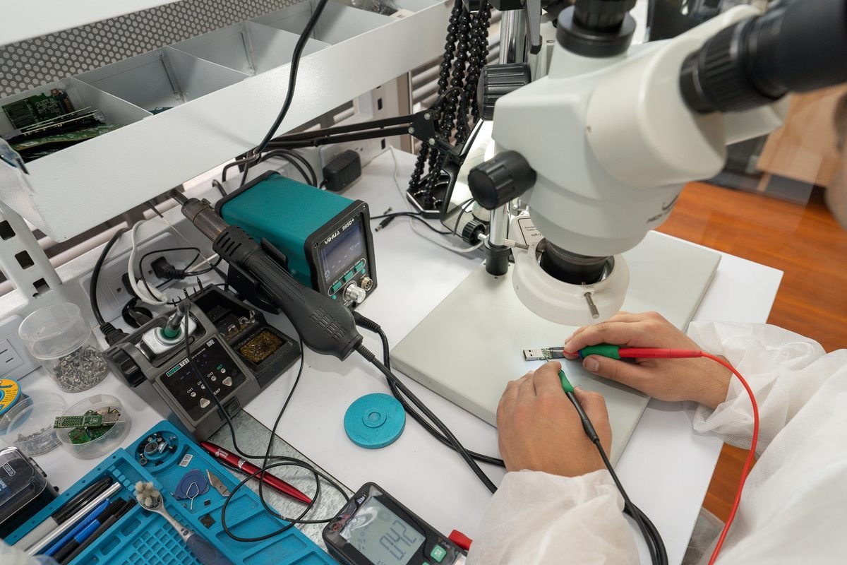 Ingeniero del laboratorio trabajando sobre una placa bajo microscopio